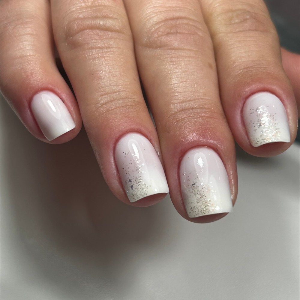 Manicura blanca con degradado de purpurina plateada